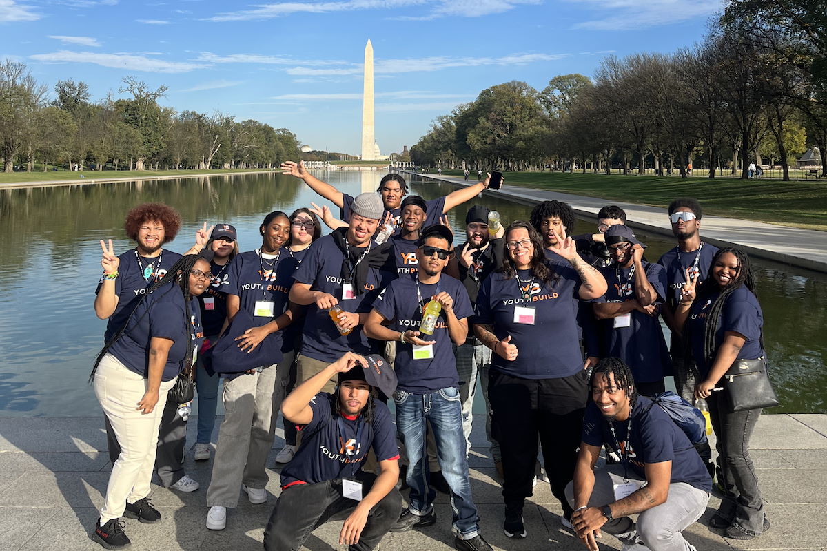 Group of smiling YouthBuild participants in front of the Washington Memorial